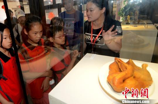 來自馬祖的小營員被在福州三坊七巷非遺博物館展出真假難辨的壽山石雕作品《鹵鴨》吸引。　記者劉可耕 攝