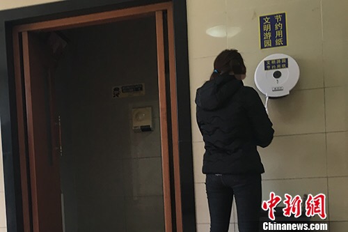 “節約用紙”的標識不僅貼在牆上，也貼在了取紙器上。湯琪 攝